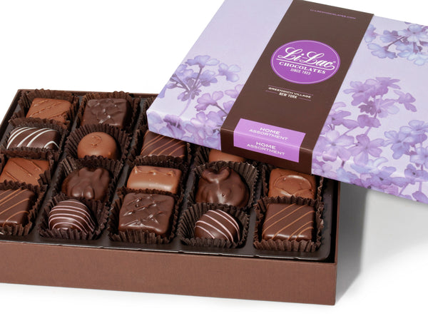 A large rectangular box of chocolate with a brown base and a purple lid with watercolor lilac motifs.