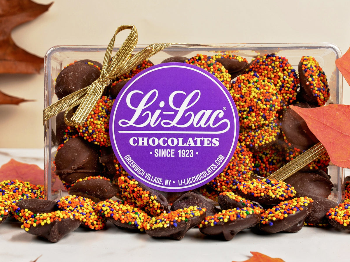 Thanksgiving colored Nonpareils in a clear box with a Li-Lac Chocolate round sticker on the lid.