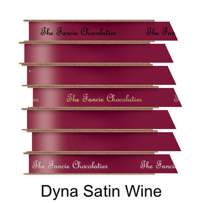A stack of seven spools of shiny wine satin ribbon with custom messages printed on them in different colors. 